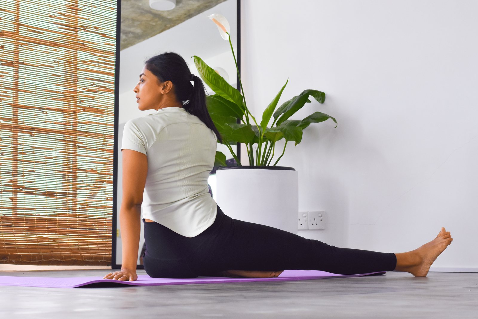 A woman practising a gentle seated stretch inside Svastha Studio in Kotte