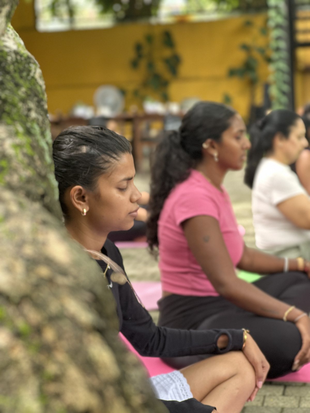 Women seated in meditation together during a small group yoga class at Svastha Studio in Kotte