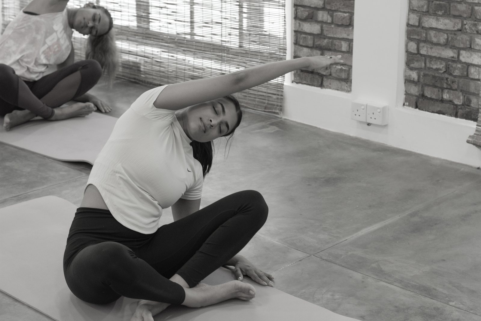 A woman practising a seated side stretch at Svastha Studio, where Flex and Flow classes take place