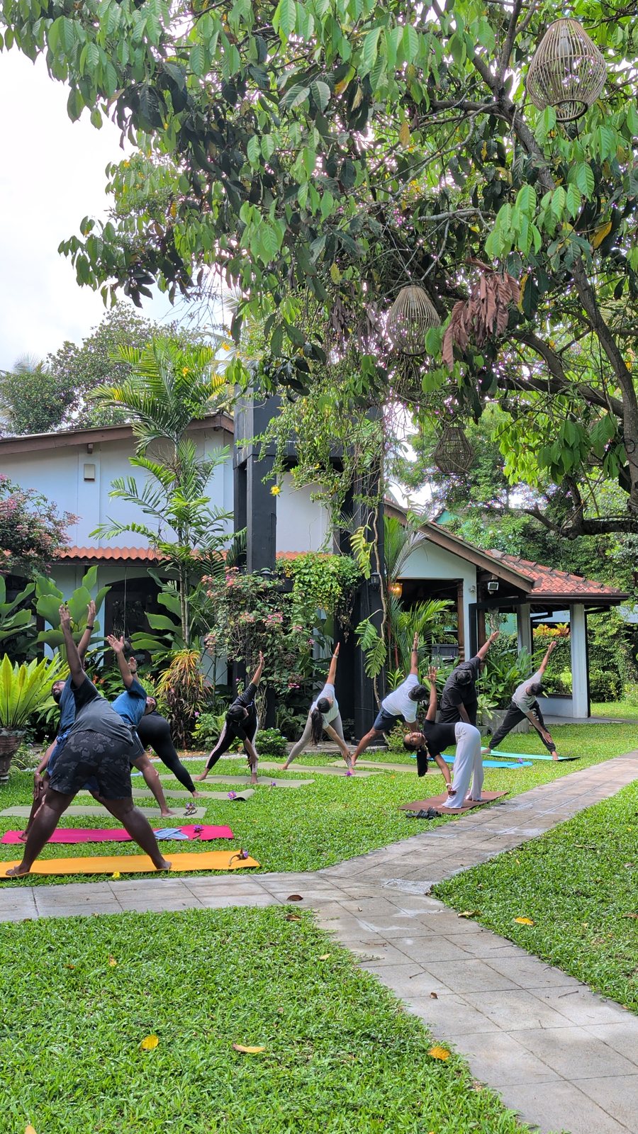 A group practising yoga on the garden terrace at Svastha Studio, showing the outdoor space